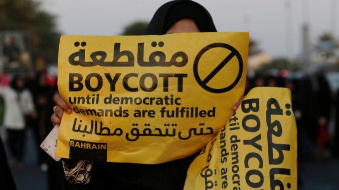 A female protester holding up a banner calling for the boycott of elections in Bahrain.